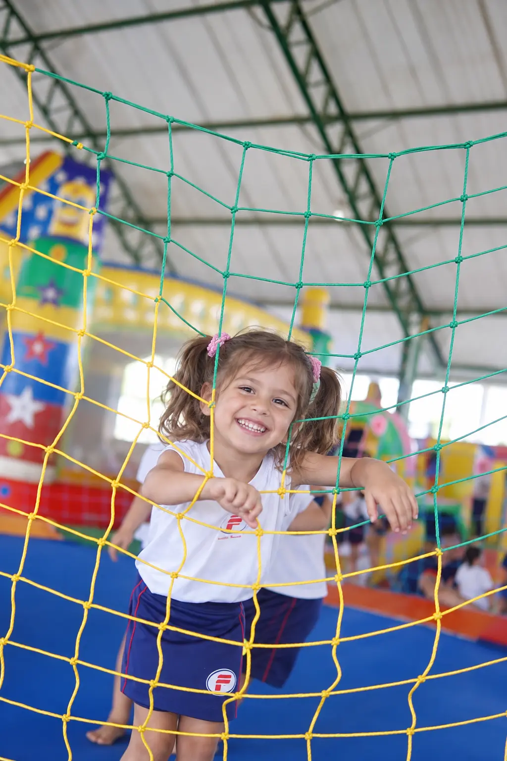 Aluna da Educação Infantil do Colégio Pierre Freitas brincando na rede do parquinho